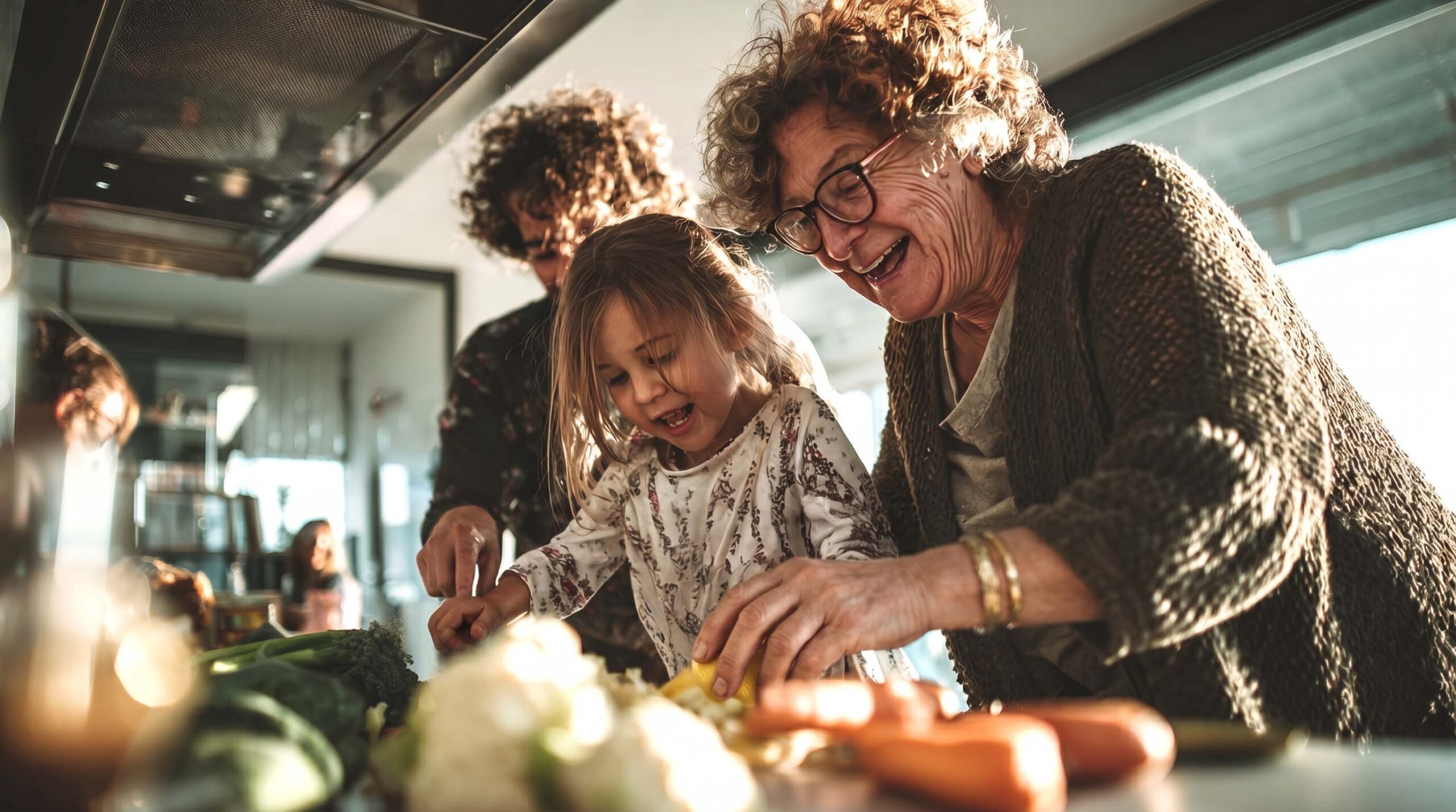 Familie mit Oma und Kind kocht Eine ältere Frau kocht gemeinsam mit einem Kind und einem Mann, alle lachen