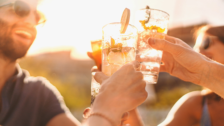Person trinkt an einem heißen Sommertag ein kühles Getränk im Freien