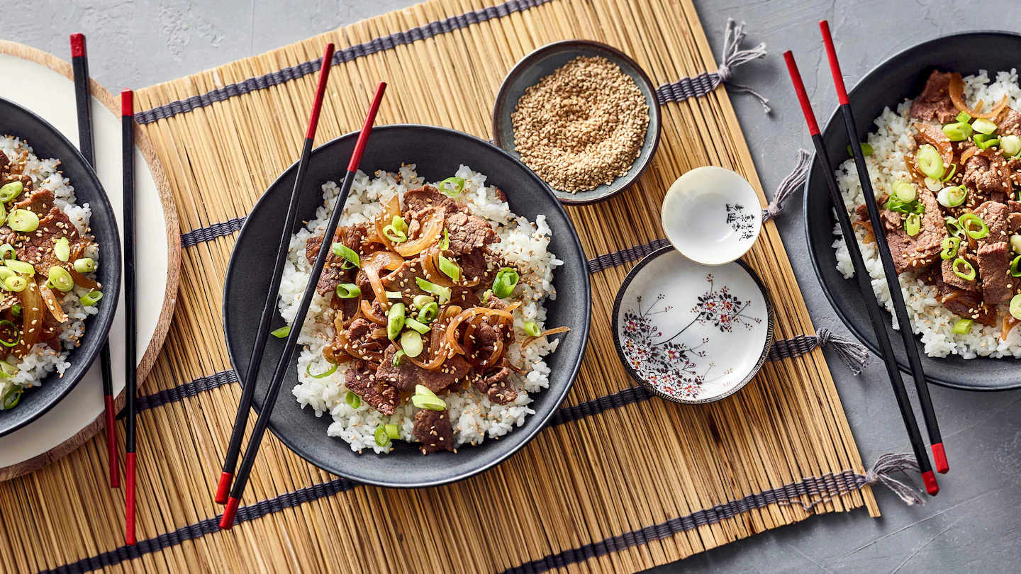 Gyudon Eine Schale Gyudon mit Reis, Rindfleisch, Zwiebeln, Frühlingszwiebeln und geröstetem Sesam
