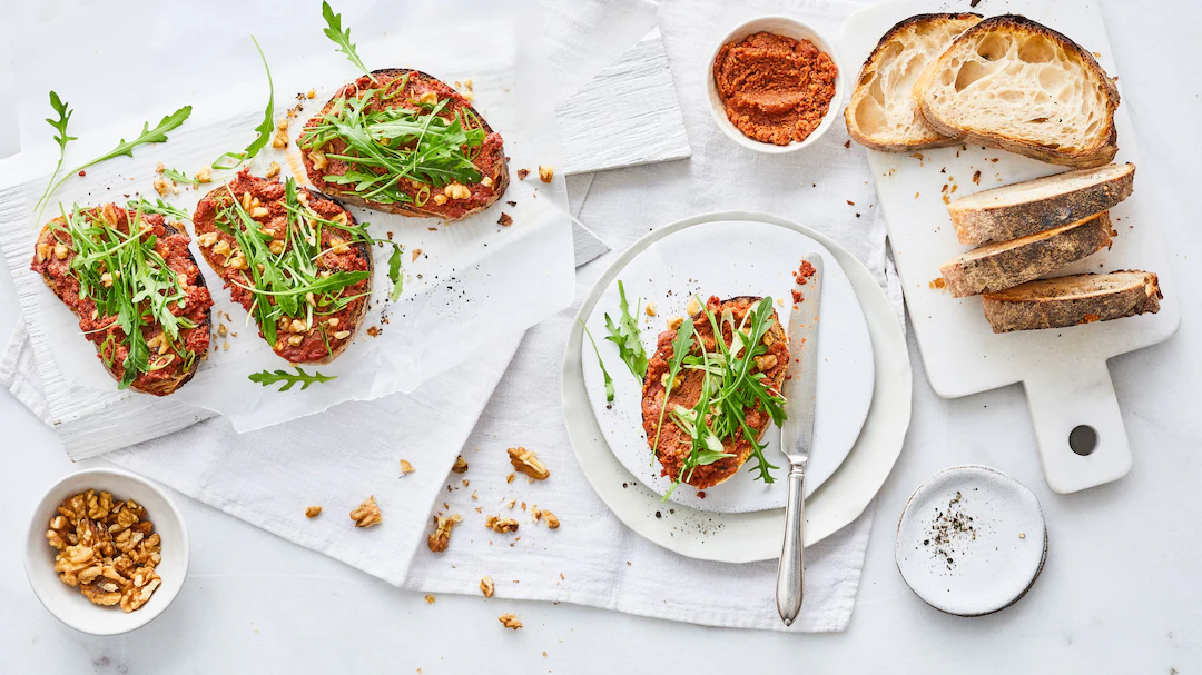 Tomate_Walnuss_Aufstrich Eine Stulle mit Tomaten-Walnuss-Aufstrich, garniert mit Rucola und Lauchzwiebeln