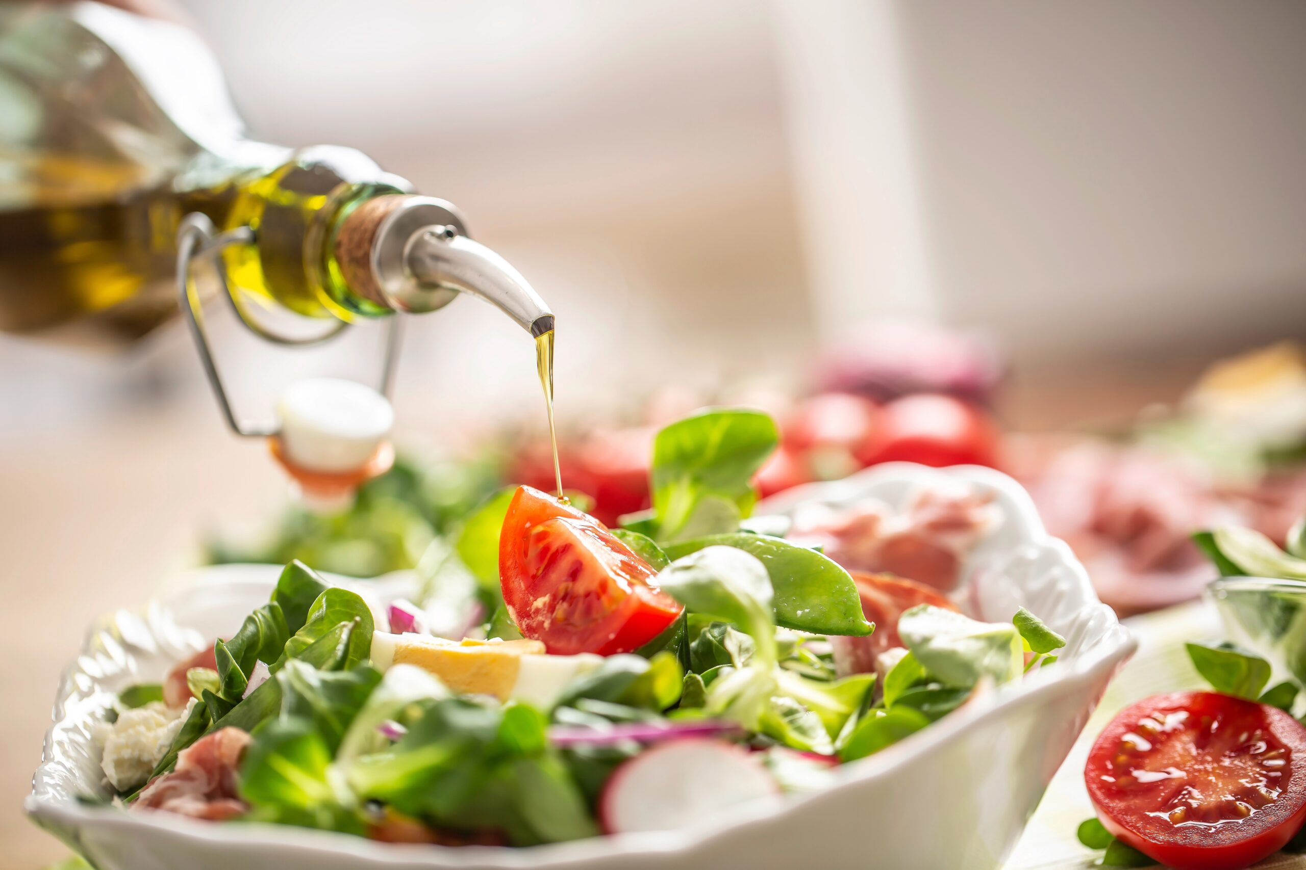 öl-auf-salt-bild Öl wird auf Salat geträufelt