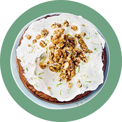Moehren-Walnusskuchen Ein Möhrenkuchen mit weißem Topping und Walnüssen darauf