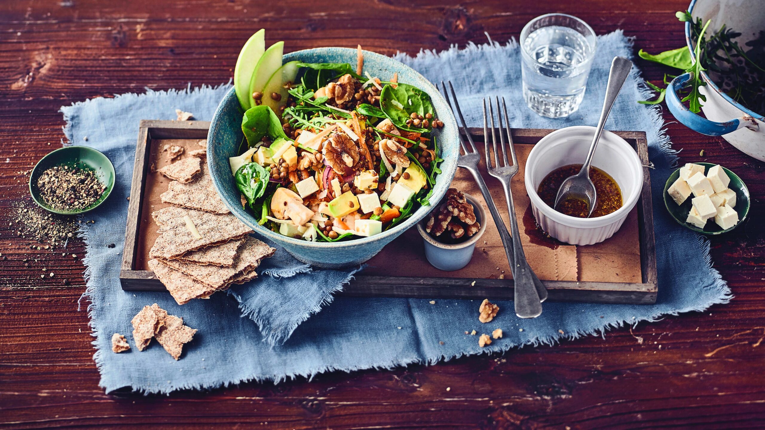 Spinat-Rucola-Feta-Salat-Edeka Ein Teller Spinat-Rucola-Feta-Salat mit Avocado, Walnüssen und Balsamico-Dressing