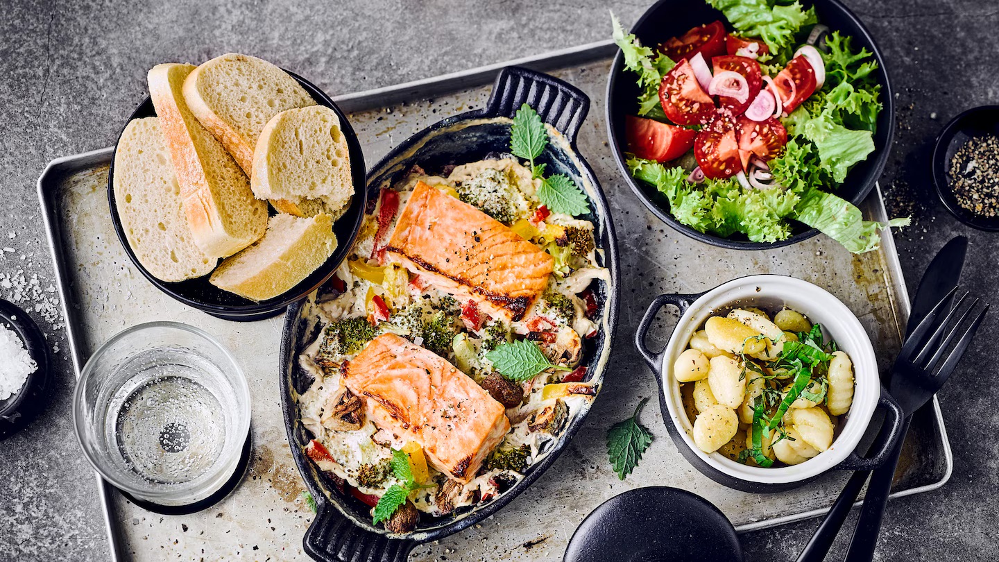 Fisch-Gemuese-Gratin-Edeka Ein Auflauf mit Lachs, buntem Gemüse und Gnocchi, serviert mit Salat und Ciabatta
