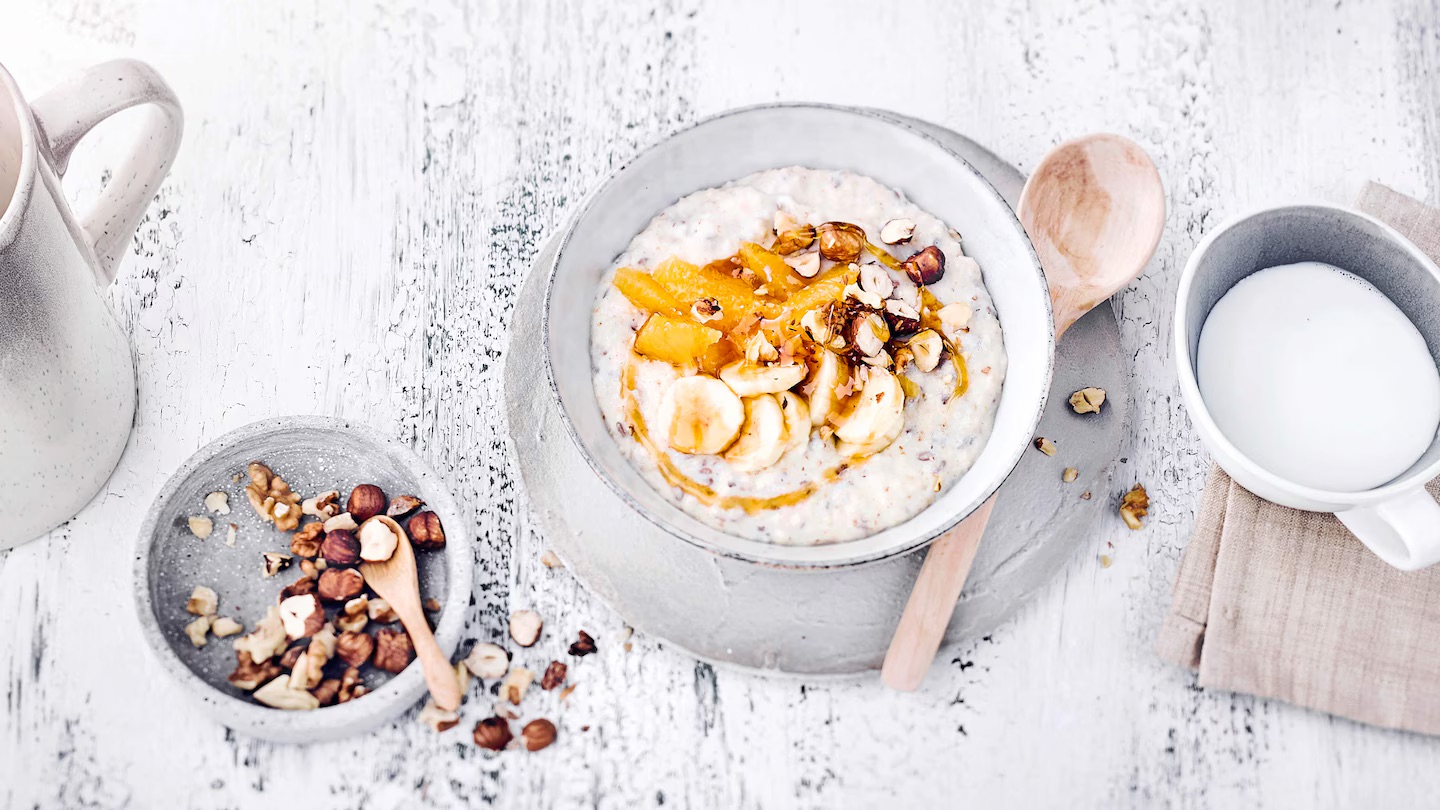 Fruehstuecksbrei-mit-Nuessen-Edeka Eine Schale Frühstücksbrei mit Orangenfilets, Bananenscheiben und gerösteten Nüssen